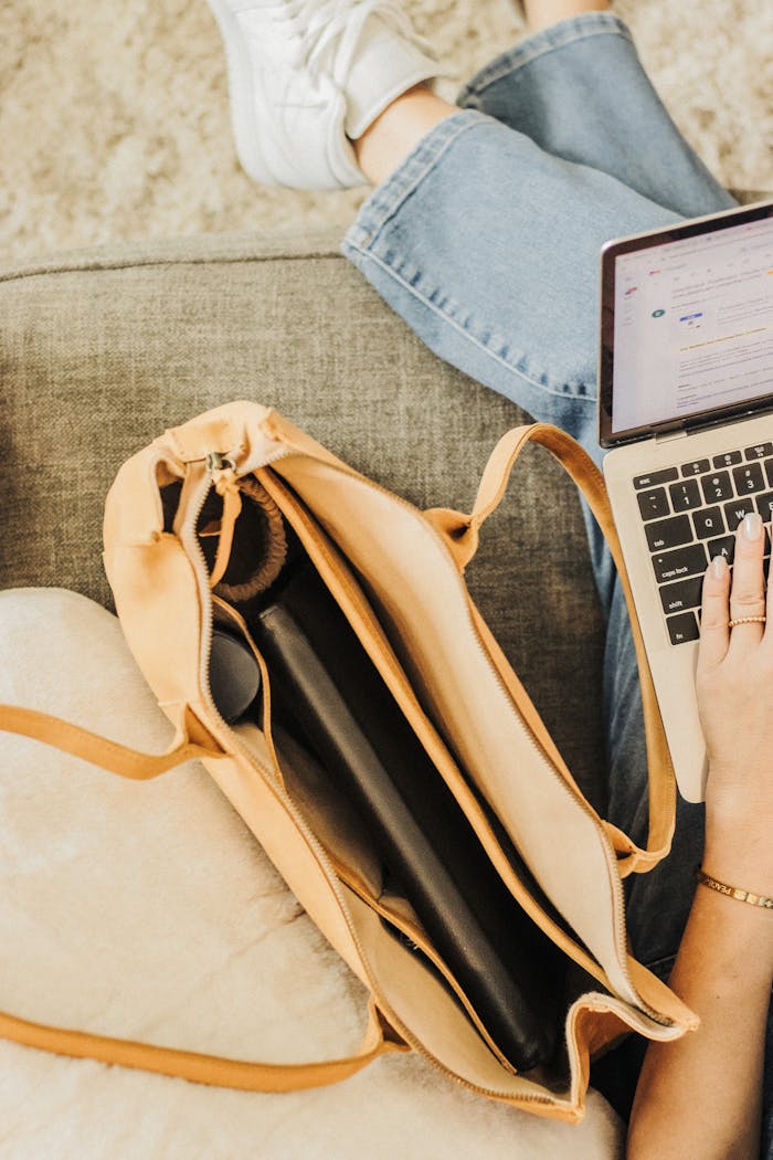Minimalist leather tote bag with laptop and essentials, perfect for modern travel and work.
